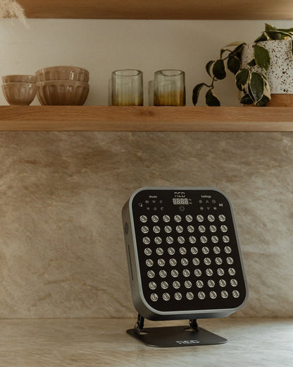 The Small Panel red light therapy device on a countertop, designed for pain relief and muscle recovery.